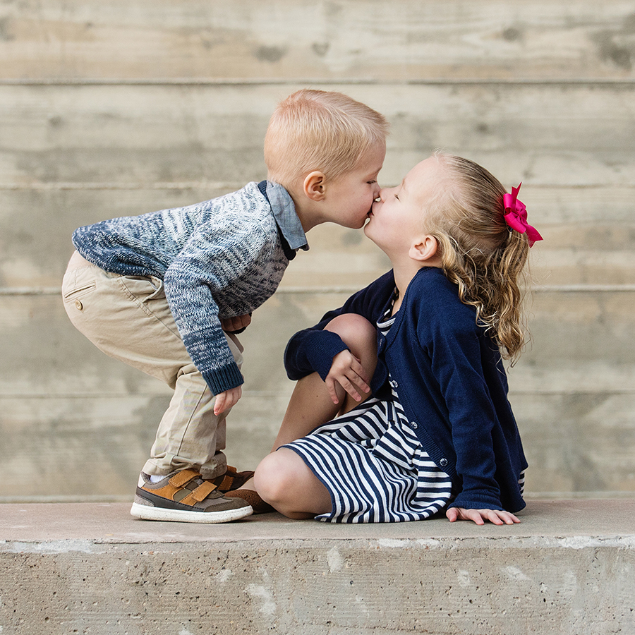 brother and sister sharing a cute moment during a photo session with Life In Motion Photography